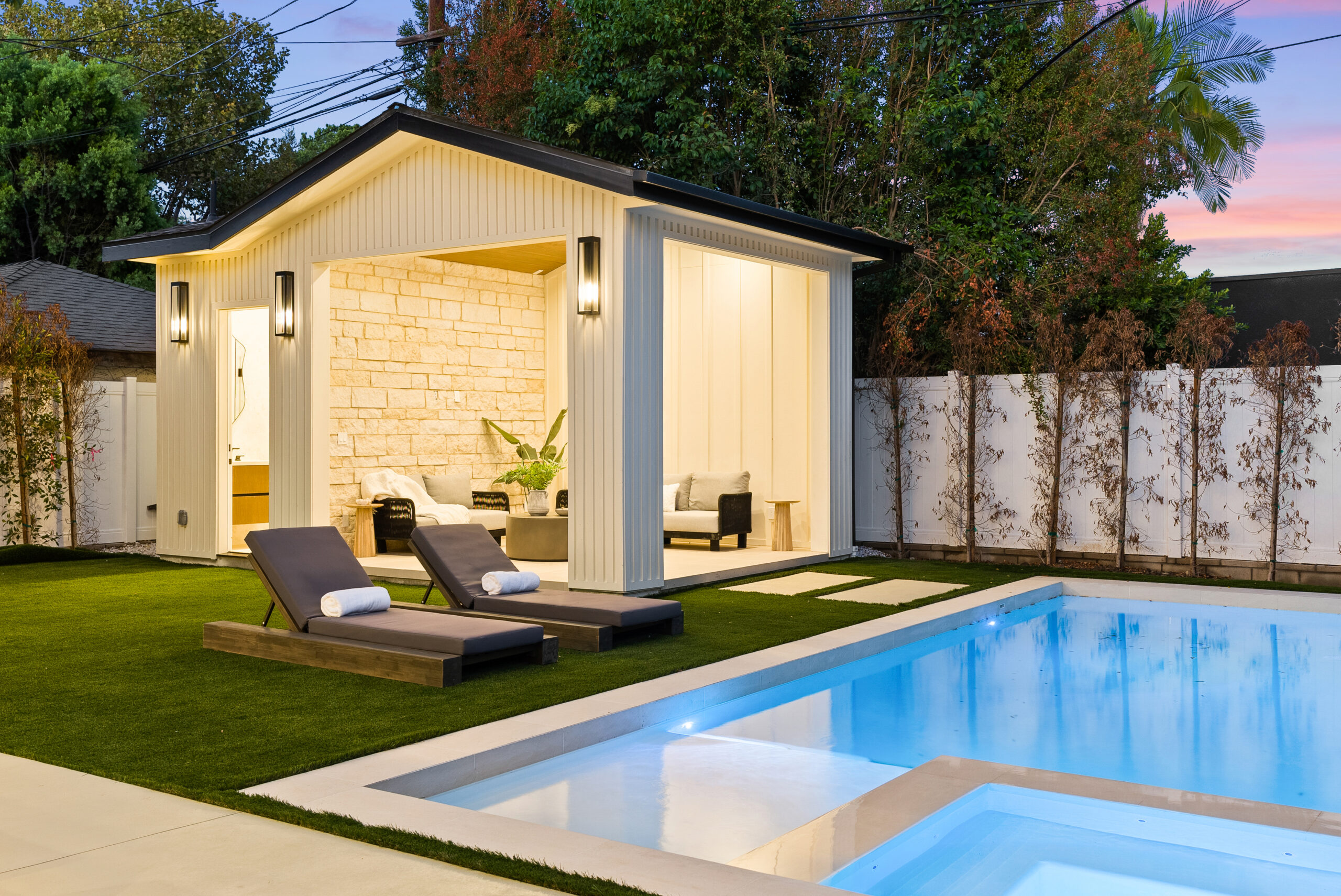 Modern backyard pool with illuminated cabana