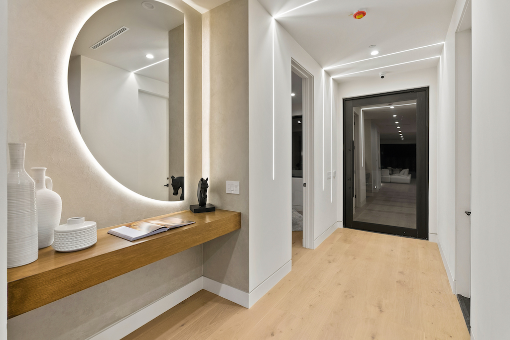 Modern entryway with round illuminated mirror
