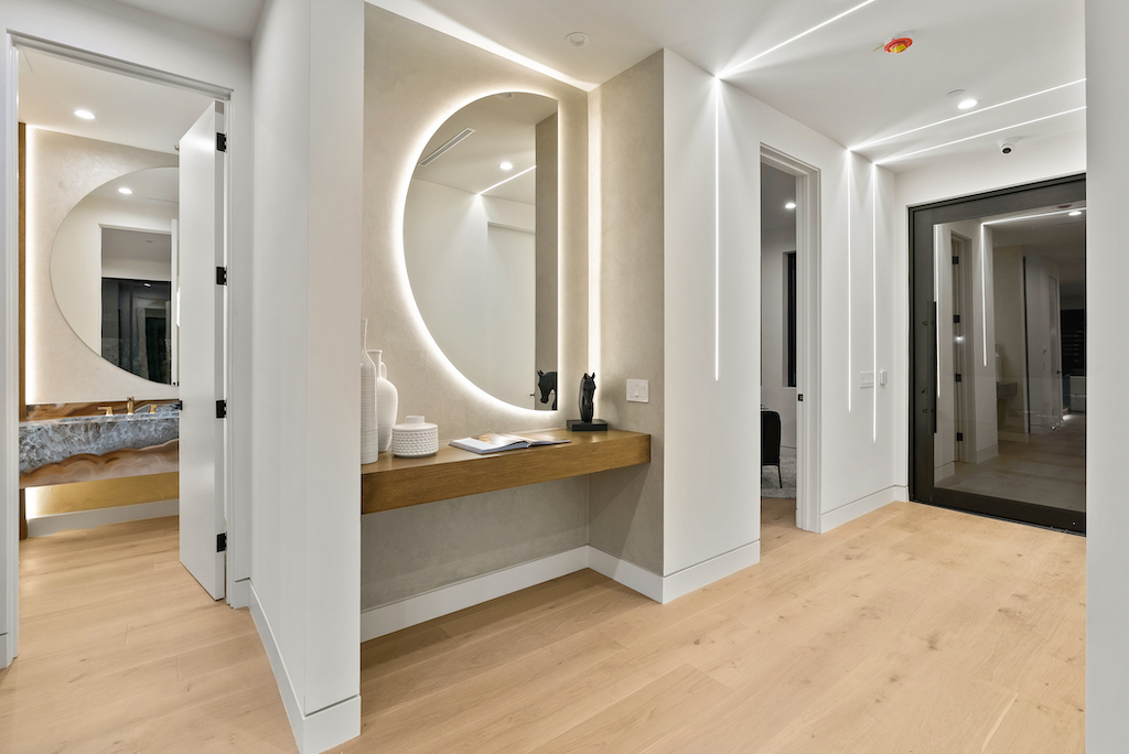 Modern entryway with backlit round mirror