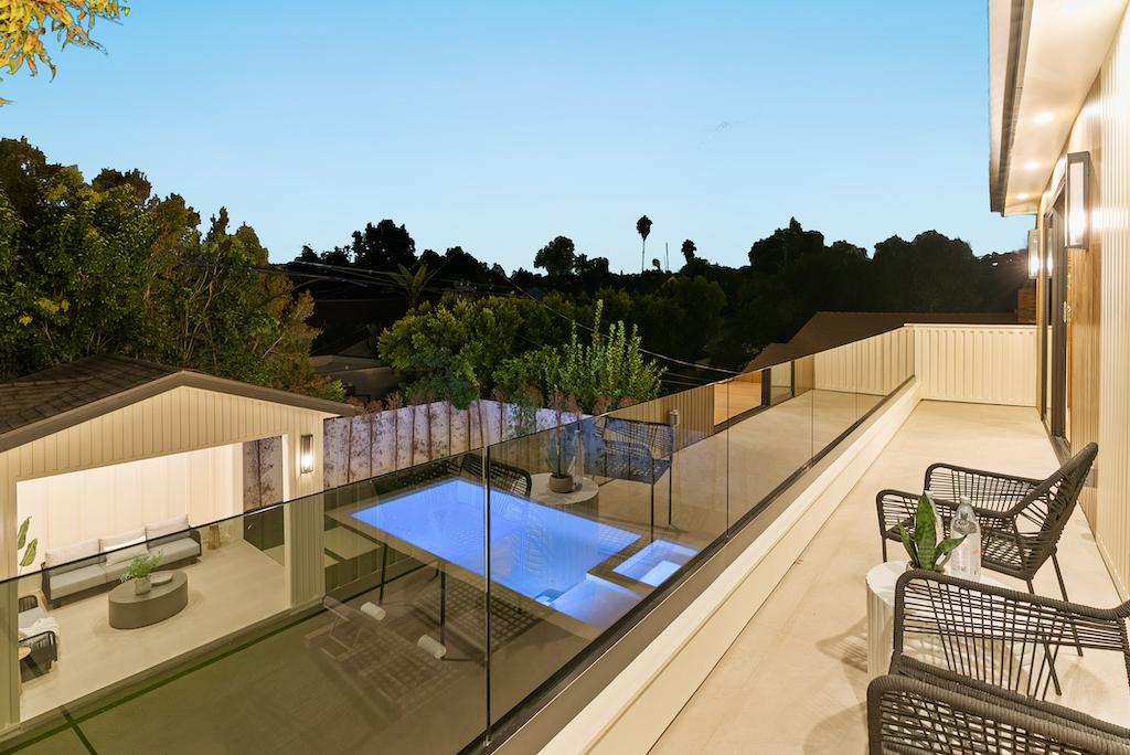 Evening balcony with glass railing and pool