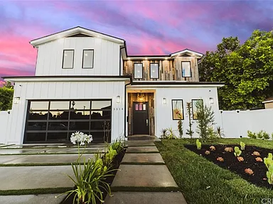 Modern two-story house with a well-lit entrance and landscaped front yard.