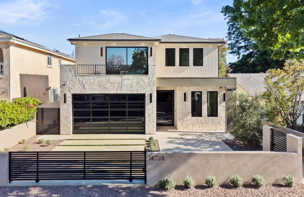 Modern two-story house with large windows and marble facade.