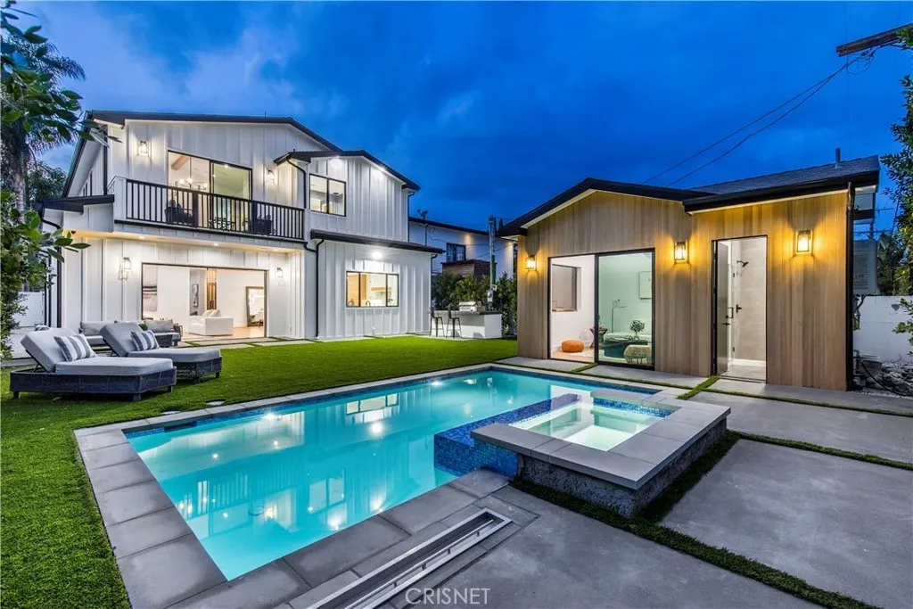 Modern house with pool and outdoor seating at dusk.