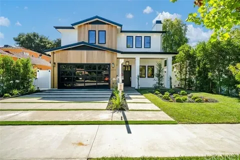 Modern two-story house with a spacious garage and well-maintained lawn.