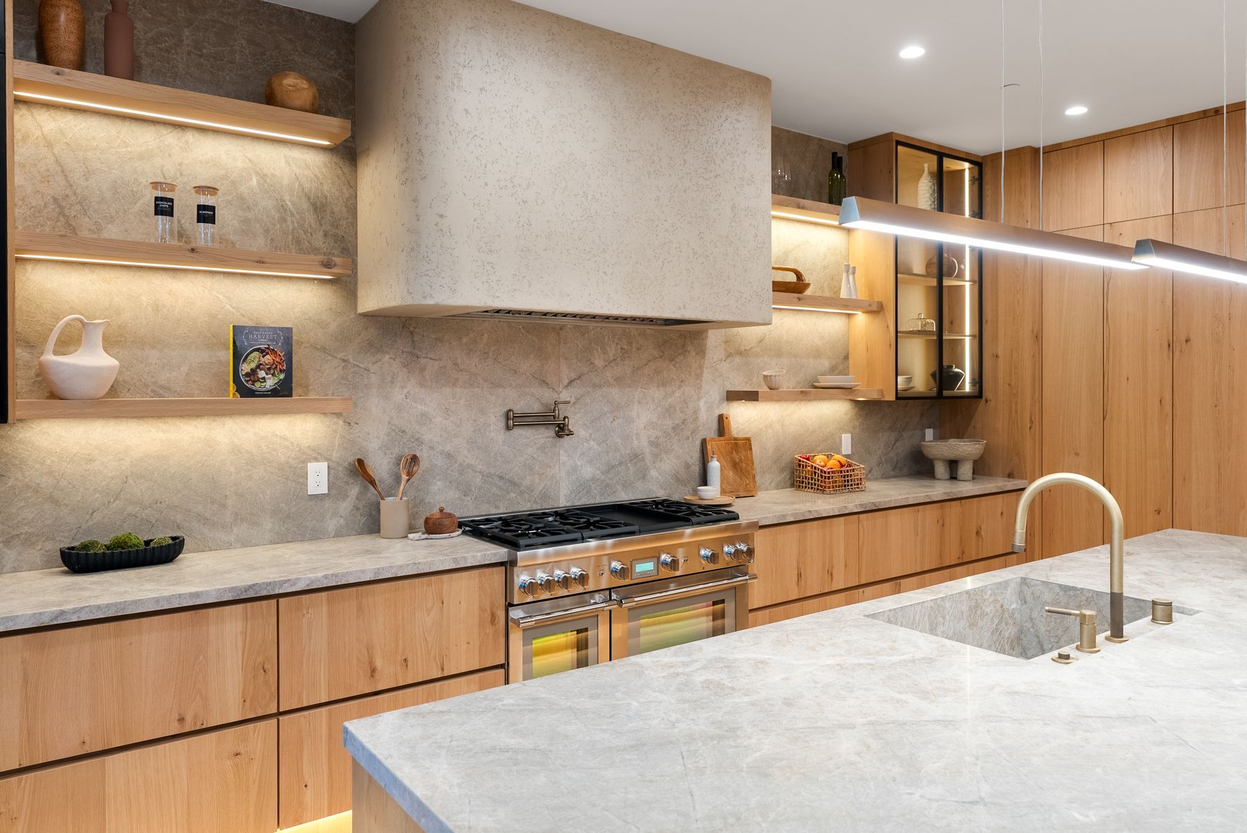 Luxury Home Builders custom home kitchen with stone backsplash at dusk