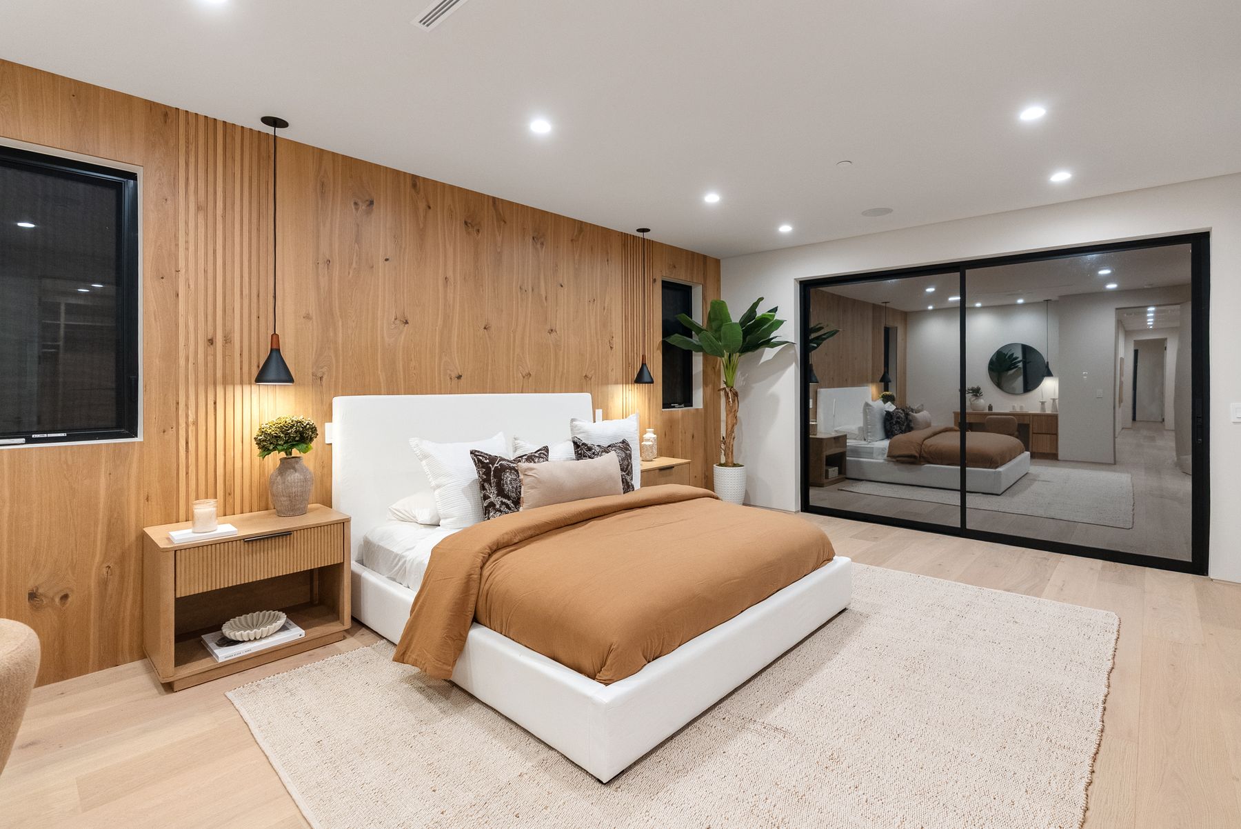 Luxury Home Builders custom home bedroom with wood headboard wall