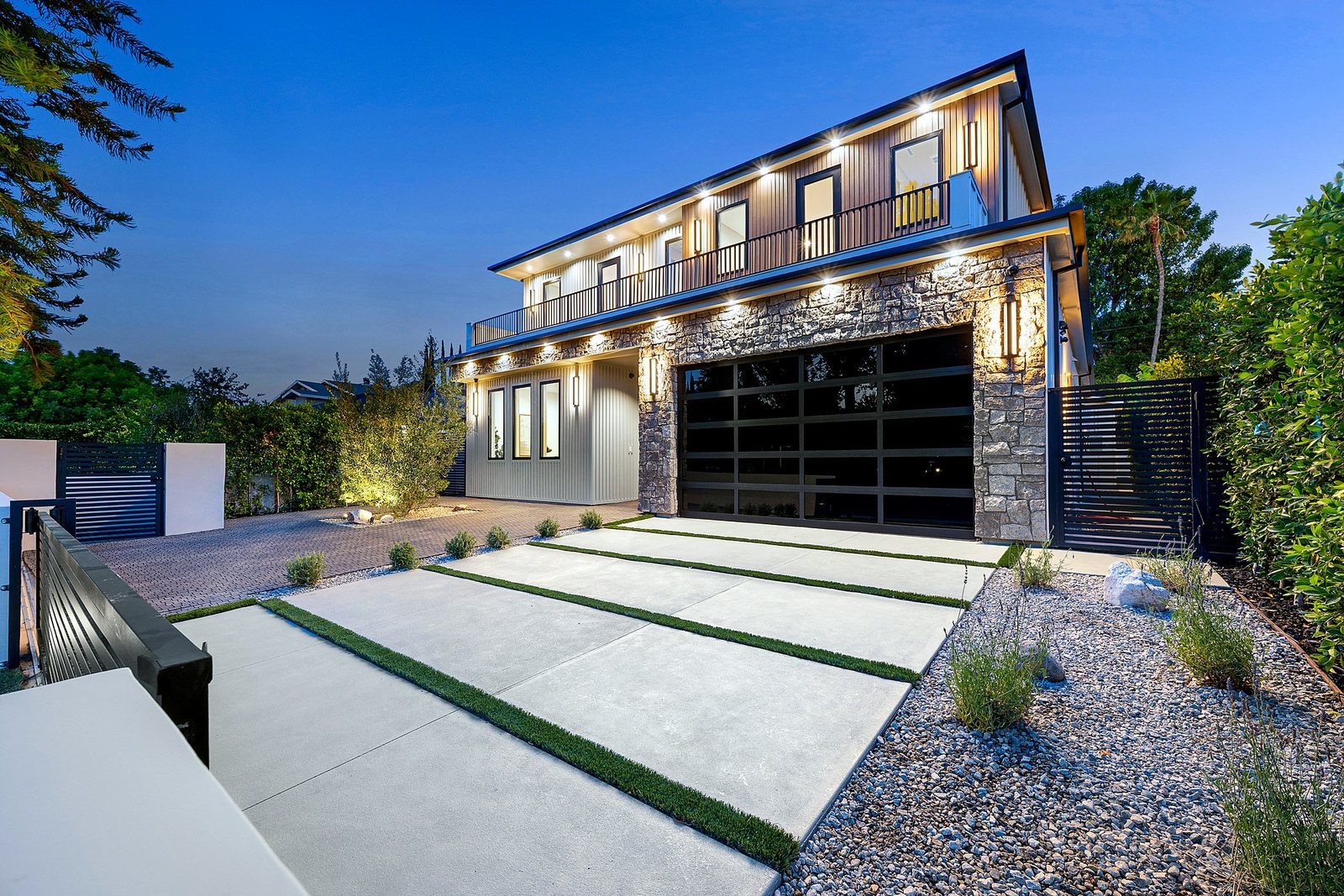 Illuminated facade of a Luxury Home Builders custom home at dusk