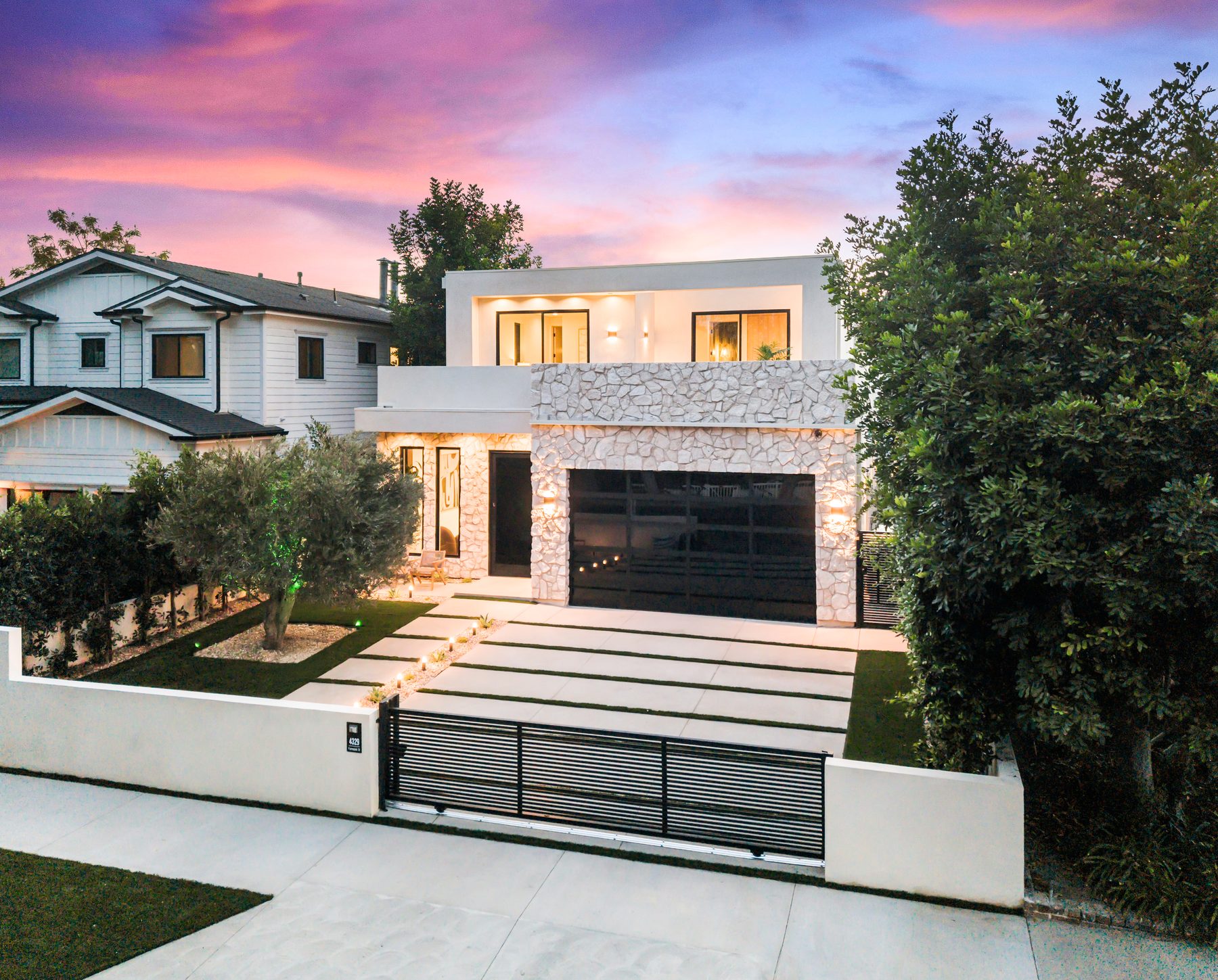 Twilight front elevation of a newly built custom home in Los Angeles, shown from the street